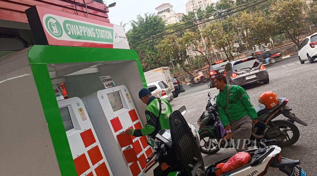 Pengemudi ojek daring menukar aki motor listrik Gesit di stasiun penukaran baterai kendaraan listrik umum (SPBKLU) SPBU Pertamina, Jalan Tentara Pelajar, Jakarta, Senin (23/10/2023).