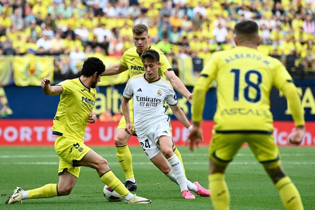 Real Madrid player Arda Guler (center) is blocked by Villarreal player Goncalo Guedes (left) during a Spanish League match at La Ceramica Stadium, Villarreal, Spain, on Sunday (May 19, 2024). The match ended in a tie 4-4.