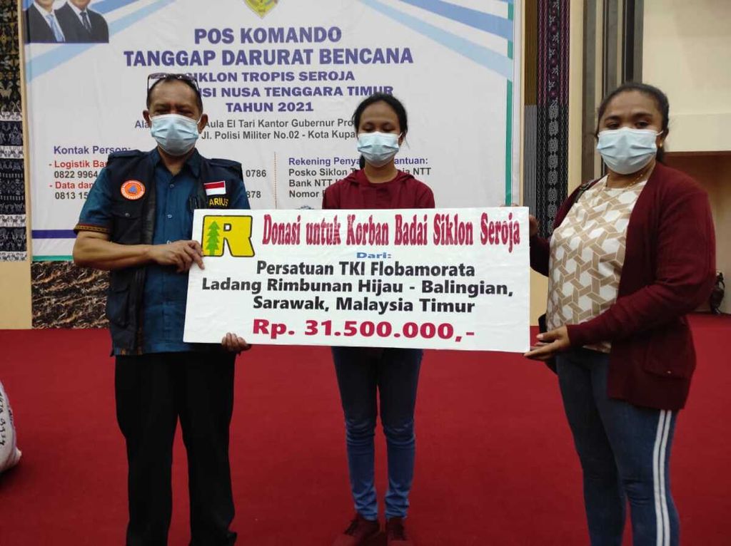 Dua perwakilan pekerja migran ilegal asal NTT yang bekerja di salah satu perkebunan sawit di Sarawak, Malaysia timur, menyerahkan bantuan bagi korban bencana badai Seroja kepada juru bicara Satgas Penanganan Bencana Badai Seroja, Marius Jelamu, di Kupang, Jumat (7/5/2021). 