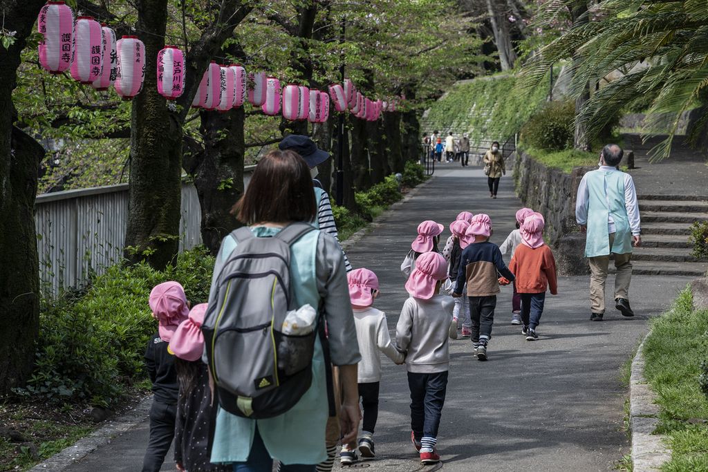 Dalam foto yang diambil pada Rabu (5/4/2023) ini tampak anak-anak diajak melewati taman saat berjalan-jalan, berdarmawisata di Tokyo. 