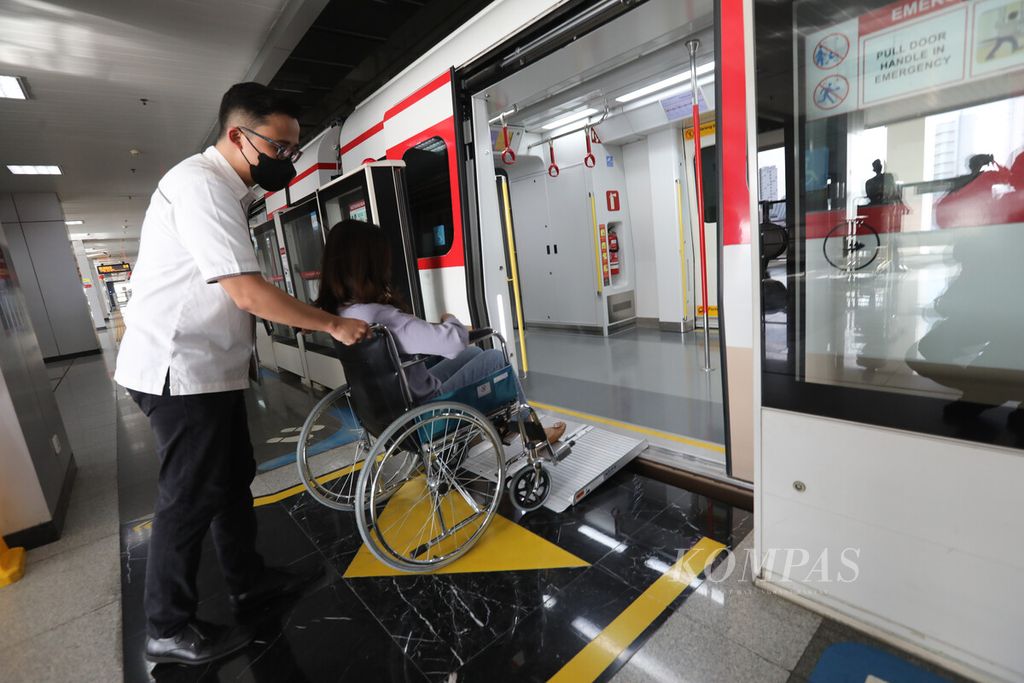 Petugas menyimulasikan pelayanan bagi penumpang difabel di rangkaian kereta LRT di Stasiun Pegangsaan Dua, Kelapa Gading, Jakarta Utara, Selasa (24/1/2023).
