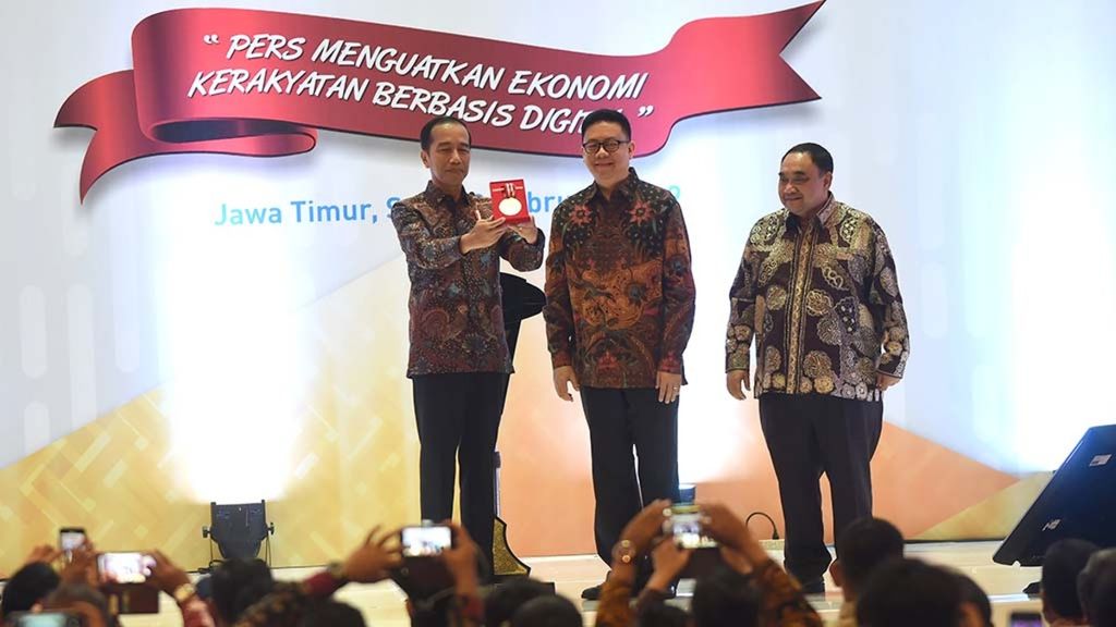 Presiden Joko Widodo menunjukkan medali Kemerdekaan Pers yang diterimanya dari Ketua Dewan Pers Yosep Adi Prasetyo (tengah), didampingi Penanggung Jawab HPN 2019 Margiono, saat puncak peringatan HPN 2019 di Grand City, Surabaya, Sabtu (9/2/2019). 