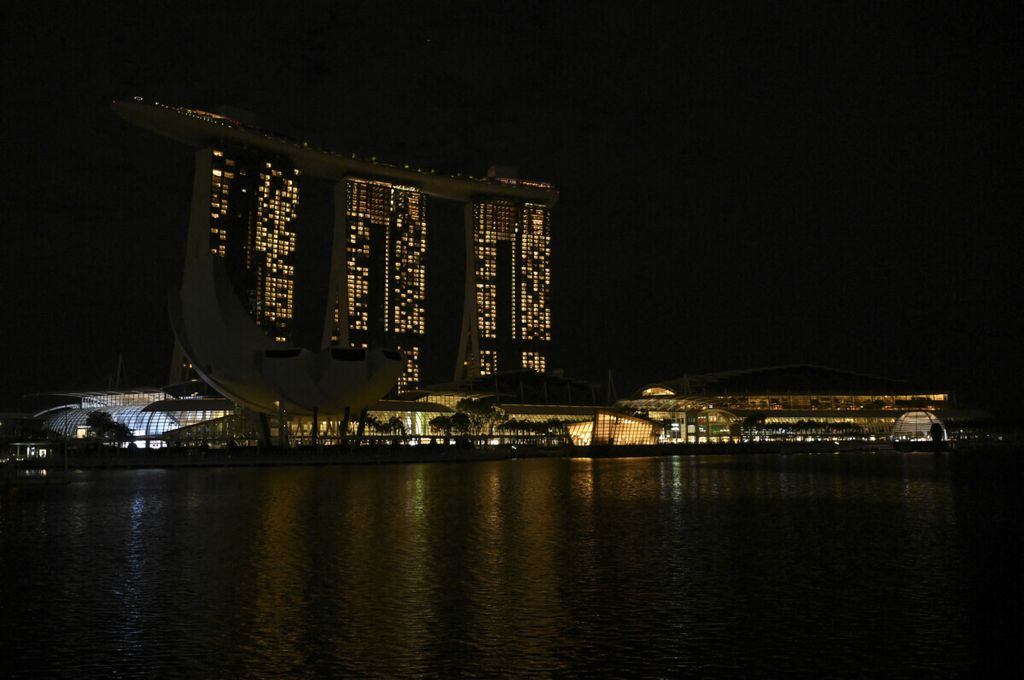 Pemandangan umum hotel dan resor Marina Bay Sands terlihat dengan dimatikannya lampu untuk kampanye lingkungan Earth Hour di Singapura pada 27 Maret 2021