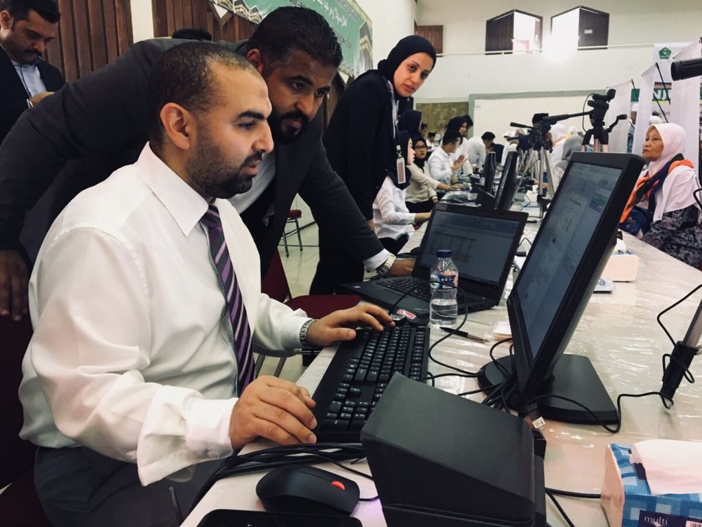 Beberapa petugas Arab Saudi sedang mengoperasikan peralatan rekam biometrik mengenakan kemeja dan dasi, Senin (16/7/2018).