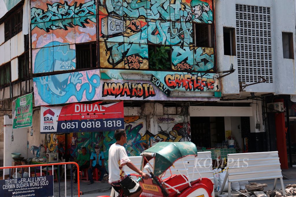 Sebuah bangunan kosong menjadi media untuk menuangkan gagasan seni visual oleh seniman di Jalan Gatot Subroto, Kota Surakarta, Jawa Tengah, Senin (26/9/2022). Dalam beberapa tahun ini, seni mural menjadi bagian dari penanda ruang publik di Kota Surakarta. 