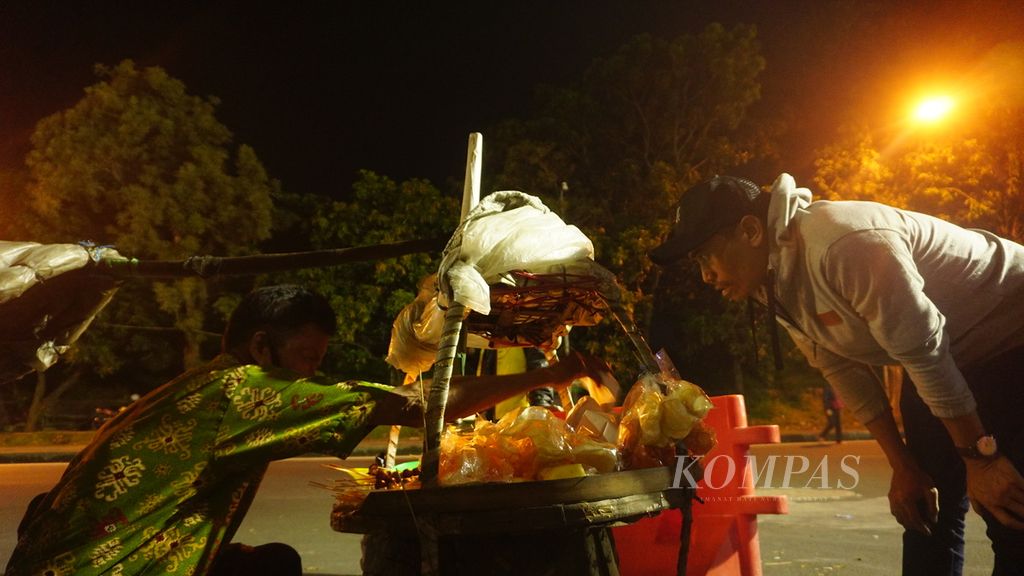Penjual hik pikul melayani pelanggan di Kota Surakarta, Jawa Tengah, Minggu (20/3/2022). Hik pikul menjadi bentuk paling awal dari kuliner murah meriah tersebut. Dalam perkembangannya, hik pikul kemudian berubah menjadi hik gerobak.
