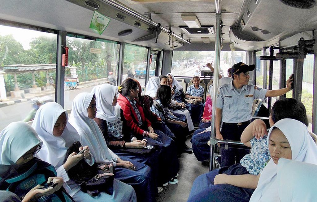 Sejumlah siswa menggunakan bus sekolah gratis, Kamis (8/6), di Jakarta. Unit Pengelola Angkutan Sekolah (UPAS) Dinas Perhubungan dan Transportasi DKI Jakarta sejak April 2016 meluncurkan aplikasi digital bus sekolah.  