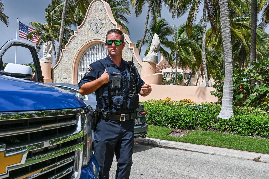 Seorang polisi berjaga di depan gerbang rumah peristirahatan mantan Presiden AS Donald Trump di Mar-a-Lago, Palm Beach, Florida, Amerika Serikat, Selasa (9/8/2022).   