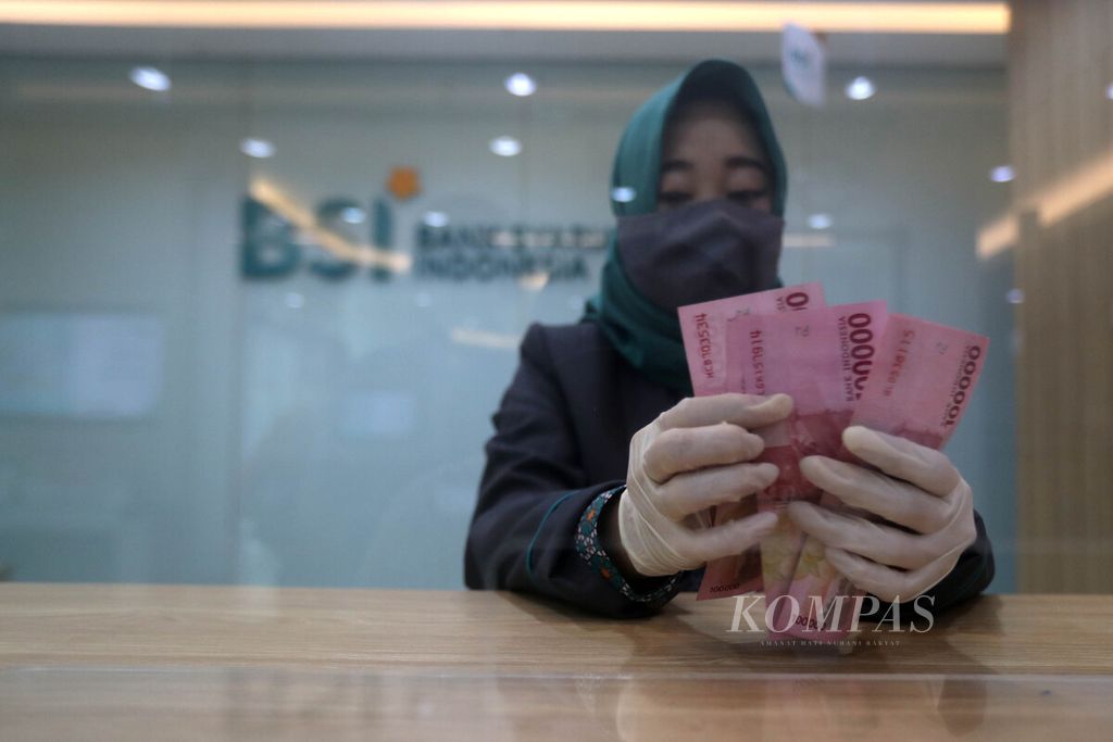 Petugas <i>teller</i> Bank Syariah Indonesia menghitung uang rupiah di Kantor Cabang Hasanudin, Blok M, Jakarta, Senin (1/2/2021). 