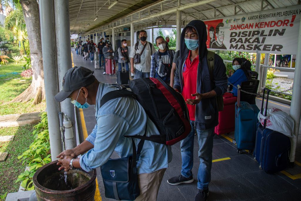 Buruh migran yang baru tiba dari Singapura diwajibkan mencuci tangan sebelum memasuki ruangan pemeriksaan dokumen di Pelabuhan Batam Centre, Kota Batam, Kepulauan Riau, Kamis (29/4/2021). 