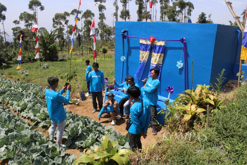 Warga RW 008 Karamat berpose di salah satu bak penampungan air bersih yang dibangun atas inisiasi Habitat for Humanity Indonesia, dan Yayasan Dana Kemanusiaan Kompas, Rabu (28/8/2024). Keberadaan bak penampungan itu menjadi bagian dari instalasi air bersih untuk warga setempat.