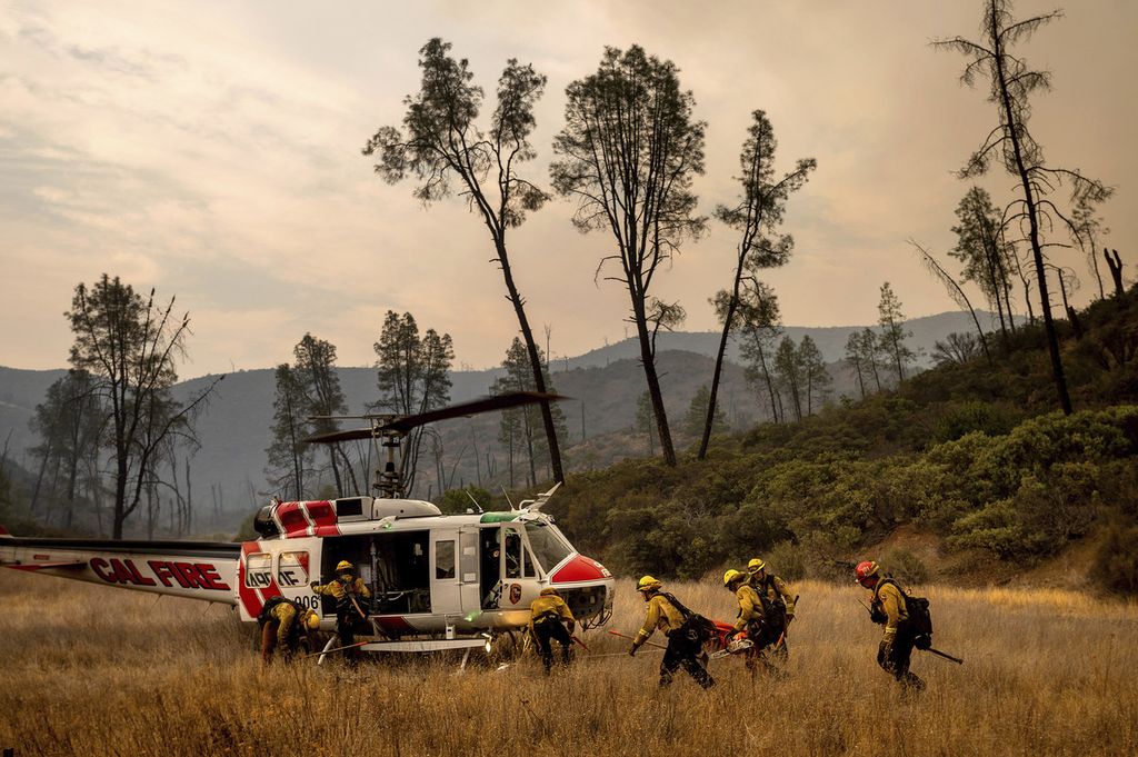Petugas pemadam kebakaran dari Howard Forest Helitack kembali ke helikopter setelah berjuang memadamkan api di LNU Lightning Complex, Lake County, California, Amerika Serikat, 23 Agustus 2020. 