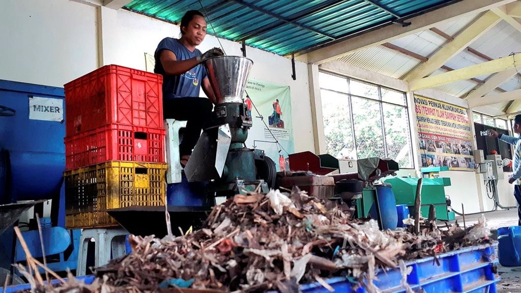 Seorang pendamping dari STT PLN Jakarta mengolah cacahan sampah menjadi pelet di lokasi Tempat Olahan Sampah Setempat (TOSS) Lepang, Kabupaten Klungkung, Bali,  pertengahan April 2019. Pelet dari sampah itu selanjutnya menjadi bahan bakar terbarukan untuk menghasilkan energi listrik.