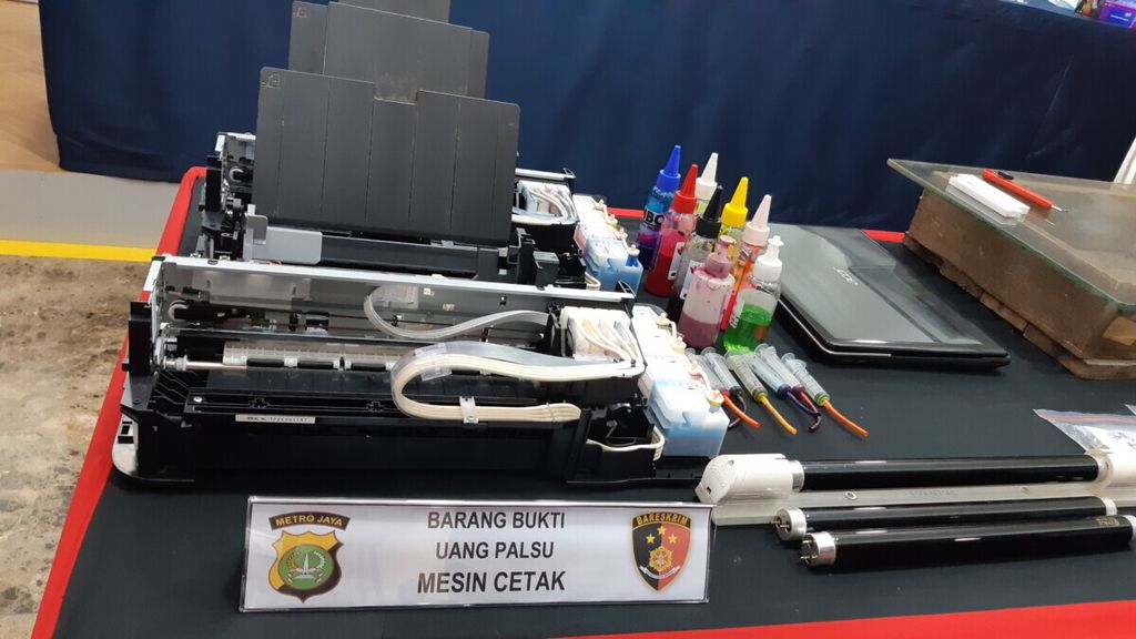 Petugas di Markas Polda Metro Jaya, Jakarta, menunjukkan barang bukti mesin pencetak untuk membuat uang palsu yang diungkap tim Subdirektorat II/Fiskal, Moneter, dan Devisa Direktorat Reserse Kriminal Khusus, Rabu (10/3/2021).