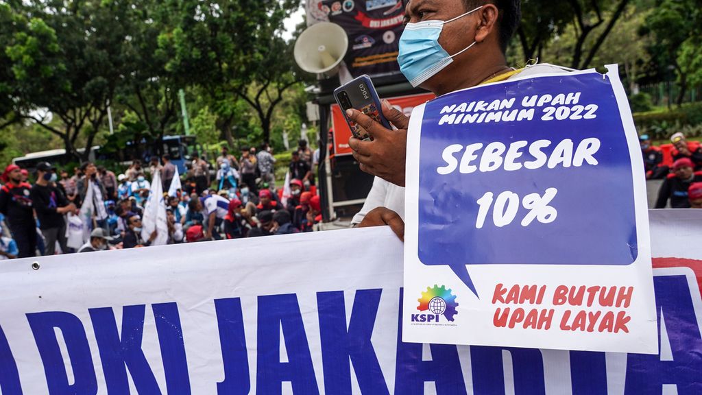 Para buruh dari Federasi Serikat Pekerja Metal Indonesia (FSPMI) dan Konfederasi Serikat Pekerja Indonesia (KSPI) menggelar aksi di depan Balai Kota DKI Jakarta, Jakarta, Jumat (19/11/2021). Aksi para buruh ini menuntut kenaikan upah minimum tahun 2022 sebesar 10 persen. Surat edaran kenaikan upah minimum buruh DKI Jakarta yang dikeluarkan Menteri Tenaga Kerja hanya sebesar 1,09 persen. Menurut para buruh, angka kenaikan sebesar 1,09 persen sangat merugikan buruh. Selain itu, angka kenaikan 1,09 persen untuk upah minimum tahun 2022 juga lebih rendah dari nilai inflasi bulan Oktober 2021 yang sebesar 1,66 persen. Perbandingan angka rekomendasi kenaikan upah dengan angka inflasi dinilai para buruh jelas tidak akan seimbang dan mencukupi pemenuhan kebutuhan hidup. 