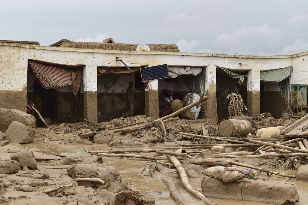 Seorang warga membersihkan puing-puing dan lumpur akibat banjir bandang yang menerjang Desa Laqiha, Provinsi Baghlan, Afghanistan, 11 Mei 2024. Setidaknya 300 orang tewas akibat bencana itu. 