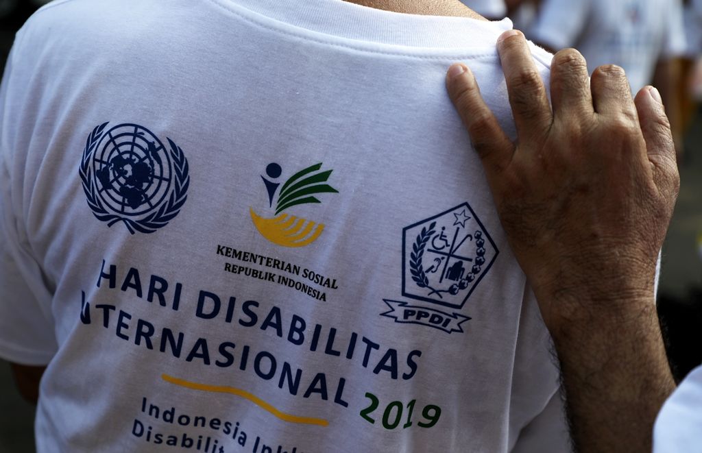 Peyandang disabilitas berpegangan saat hadir dalam peringatan Hari Disabilitas Internasional 2019 di Kompleks Gelora Bung Karno, Jakarta, Minggu (1/12/2019). 