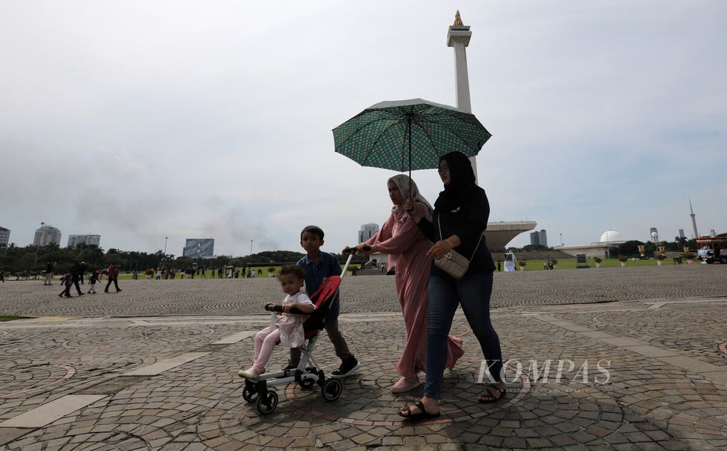 Warga menikmati hari libur di kawasan lapangan Monas, Jakarta Pusat, Selasa (25/4/2023). Sinar ultraviolet kategori ekstrem melanda sebagian besar wilayah Indonesia, terutama di kawasan timur dan tengah.