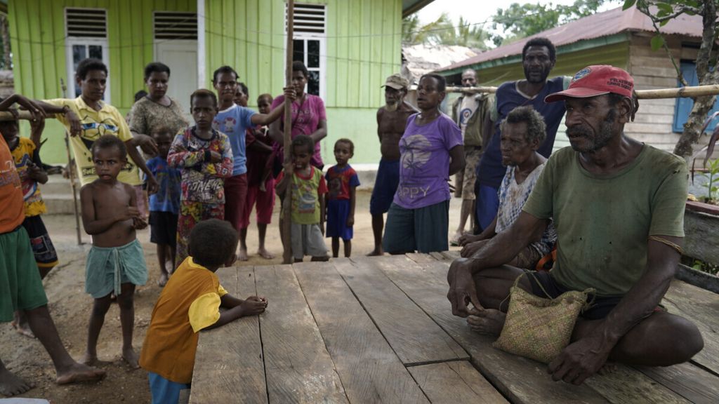 Bonifasius Gebze (kanan, bertopi) duduk bercengkerama dengan warga di Kampung Zanegi, Distrik Animha, Kabupaten Merauke, Papua Selatan, 10 Maret 2020. 