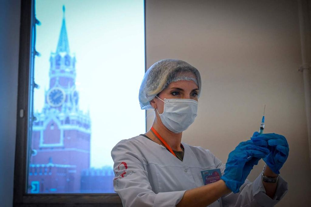 Seorang perawat tengah menyiapkan satu dosis vaksin Sputnik V Covid-19 yang akan disuntikkan pada seorang penerima vaksin di pusat vaksinasi di GUM, sebuah pusat perbelanjaan terkemuka di Moskwa. Foto diambil pada Kamis (13/1/2022).