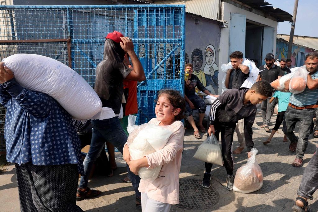 Warga Palestina menyerbu Pusat Pasokan Bantuan PBB yang mendistribusikan makanan kepada keluarga-keluarga pengungsi, Sabtu (28/10/2023). 