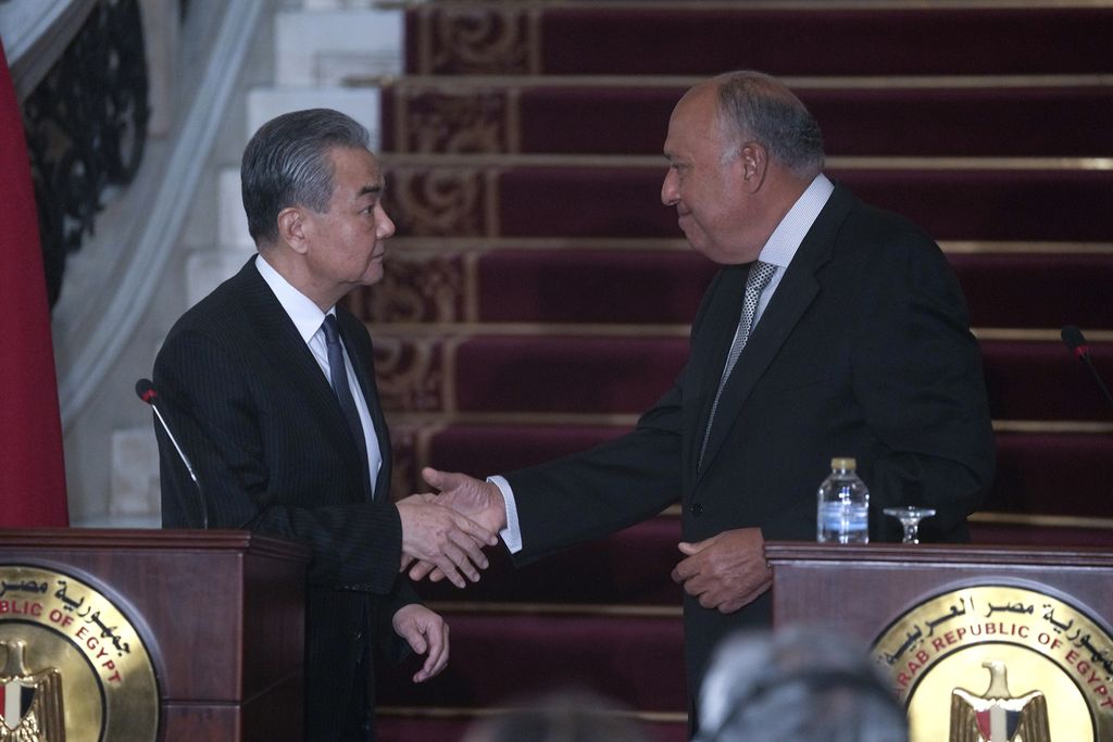 Menteri Luar Negeri China Wang Yi (kiri) dan Menlu Mesir Sameh Shoukry berjabat tangan setelah konferensi pers bersama di Istana Tahrir, Kairo, Mesir, Minggu (14/1/2024). 