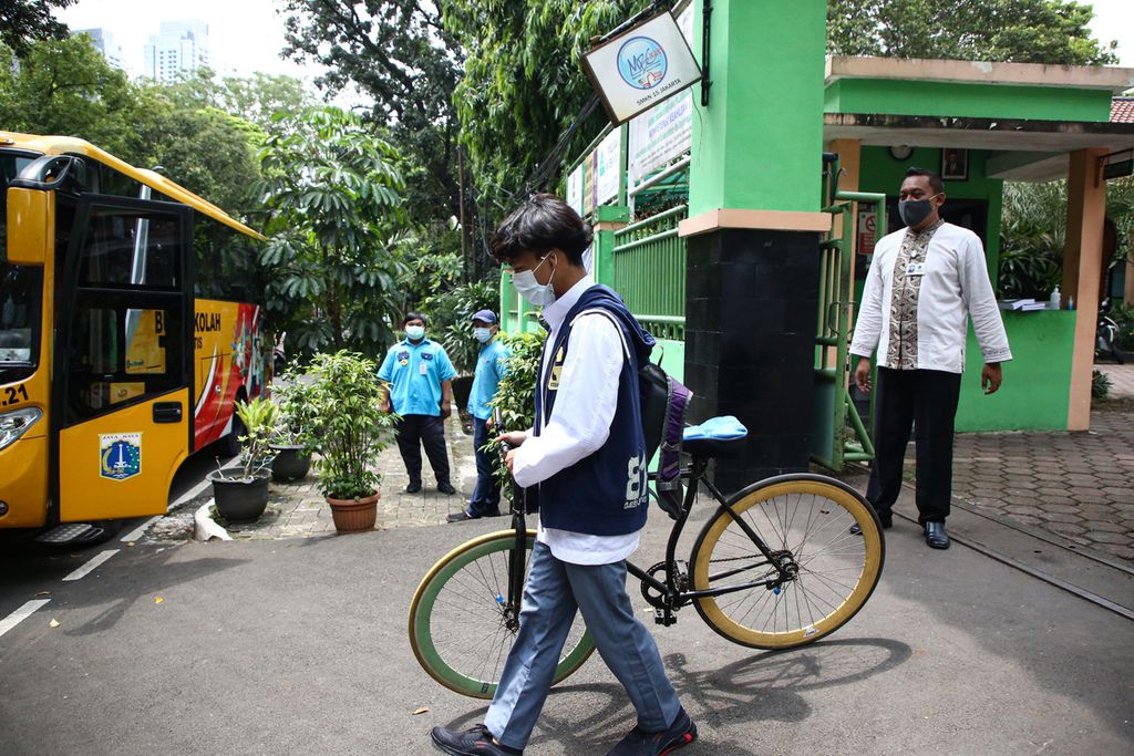 Siswa menggunakan sepeda seusai mengikuti uji coba pembelajaran tatap muka di masa pandemi Covid-19 di SMK Negeri 15 Jakarta, Jumat (9/4/2021).