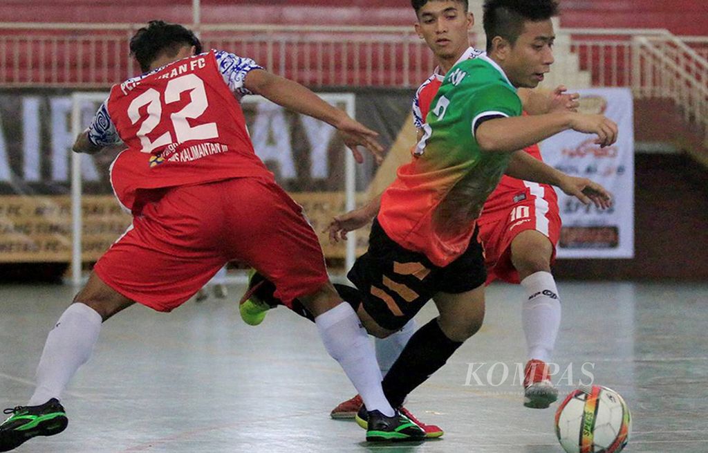 Pemain    Halus FC Jakarta (tengah) berusaha menghindari hadangan dua pemain  Pengairan FC Samarinda, Kalimantan Timur, dalam laga lanjutan Piala Emas Futsal Indonesia 2017, Senin (17/7), di GOR Ciracas, Jakarta Timur. Laga itu dimenangi Halus FC dengan skor 8-4.  