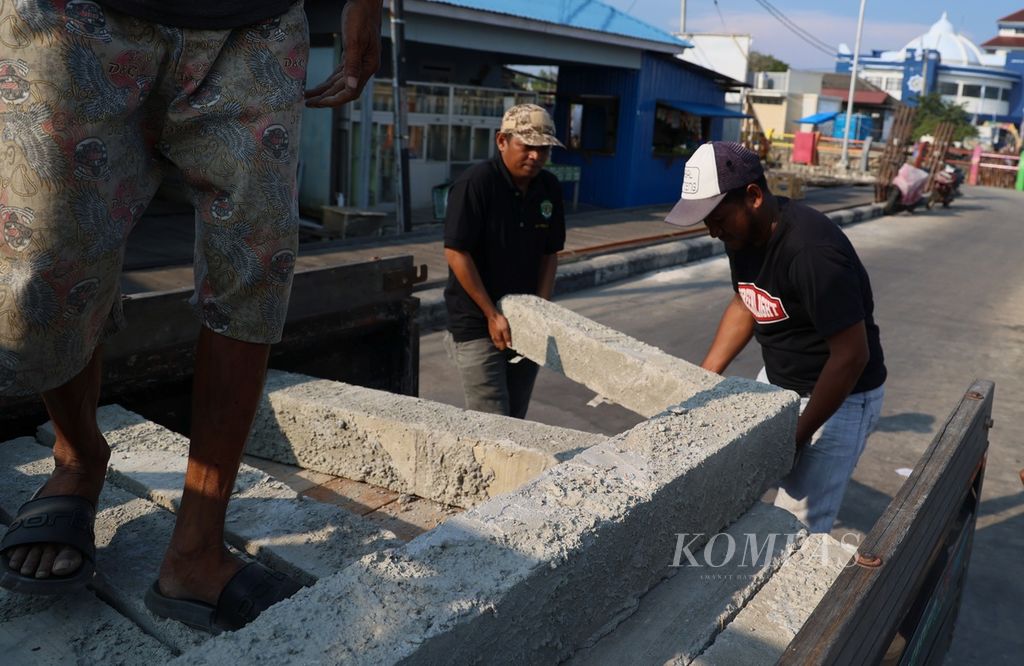 Pekerja menurunkan material untuk terumbu karang buatan dari atas mobil pengangkut di Kampung Selambai, Kelurahan Lok Tuan, Kecamatan Bontang Utara, Bontang, Kalimantan Timur, Sabtu (21/10/2023). 