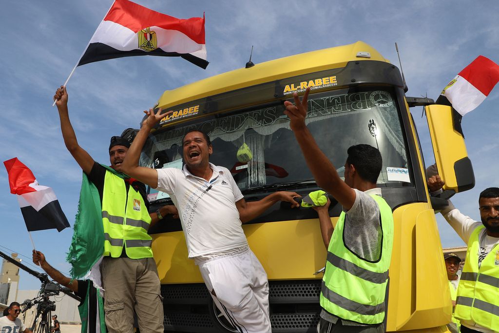 Petugas kemanusiaan Mesir merayakan pembukaan gerbang perbatasan dengan Jalur Gaza di Rafah, 21 Oktober 2023. Rombongan pertama bantuan kemanusiaan mulai masuk ke Jalur Gaza. 