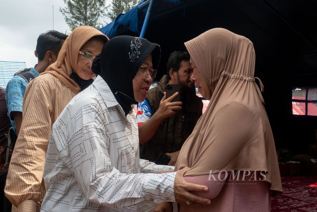 Sunarti (kanan) yang menangis ditenangkan oleh Menteri Sosial Tri Rismaharini di pengungsian korban bencana longsor di SMA Negeri 1 Serasan, Pulau Serasan, Kabupaten Natuna, Kepulauan Riau, Jumat (10/3/2023). Suami Sunarti meninggal akibat longsor pada 6 Maret lalu.