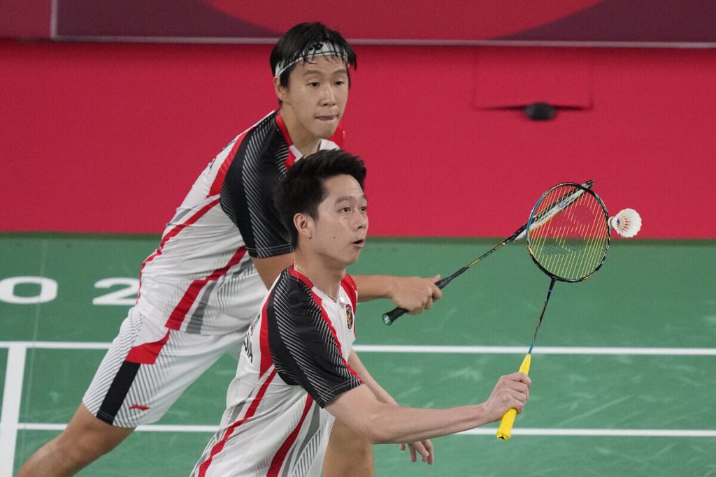 Marcus Fernaldi Gideon (atas) dan Kevin Sanjaya Sukamuljo saat melawan Aaron Chia/Soh Wooi Yik dari Malaysia, 29 Juli 2021, dalam pertandingan perempat final cabang bulu tangkis Olimpade Tokyo 2020.