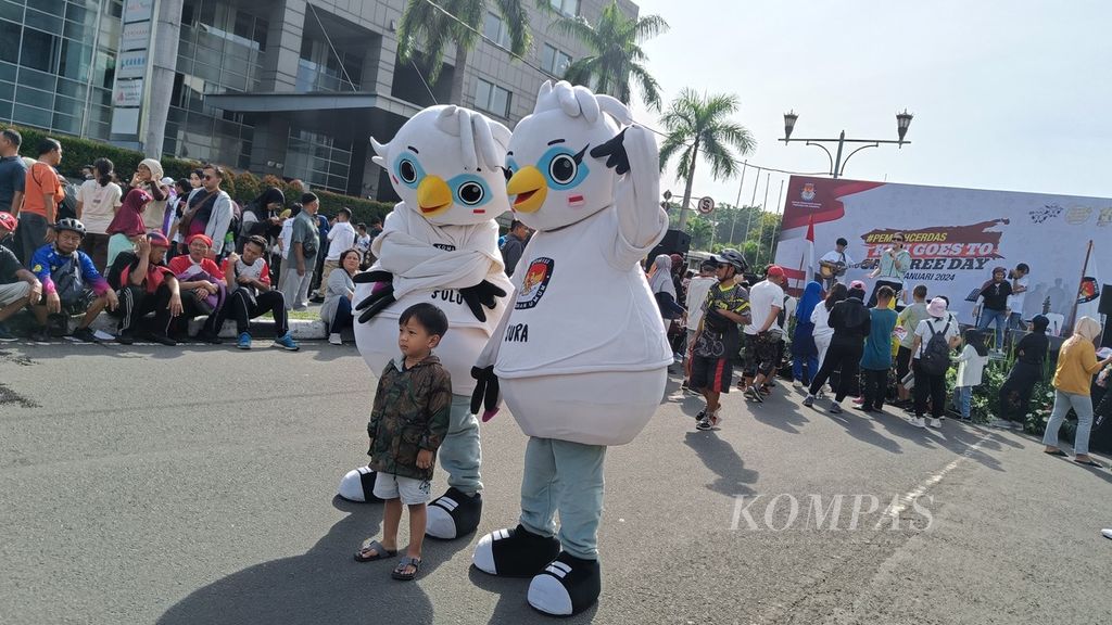 Maskot Pemilu 2024 dari KPU, Sura dan Sulu, tengah berfoto bersama anak-anak pengunjung hari bebas kendaraan bermotor (HBKB) atau <i>car free day</i> di Bundaran HI, Jakarta, Minggu (14/1/2024).