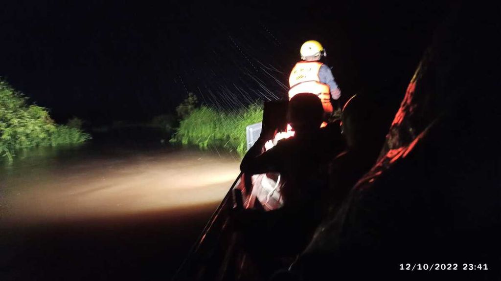 Petugas melewati banjir di rawa gambut untuk menuju lokasi tower transmisi yang terganggu akibat pohon tumbang di wilayah Katingan, Kalimantan Tengah, Selasa (11/10/2022).
