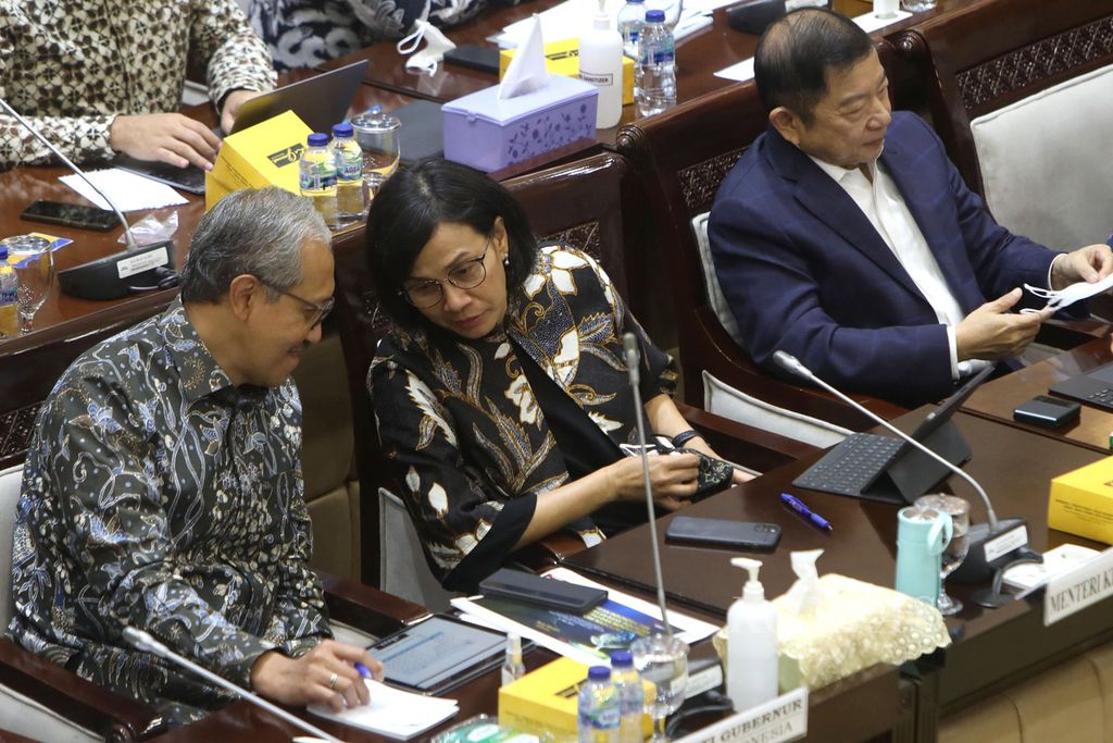 Menteri Keuangan Sri Mulyani Indrawati berbincang-bincang dengan Deputi Gubernur Bank Indonesia Dody Budi Waluyo (kiri) dalam rapat kerja dengan Komisi XI DPR di Kompleks Gedung Parlemen, Senayan, Jakarta, Rabu (8/6/2022). 