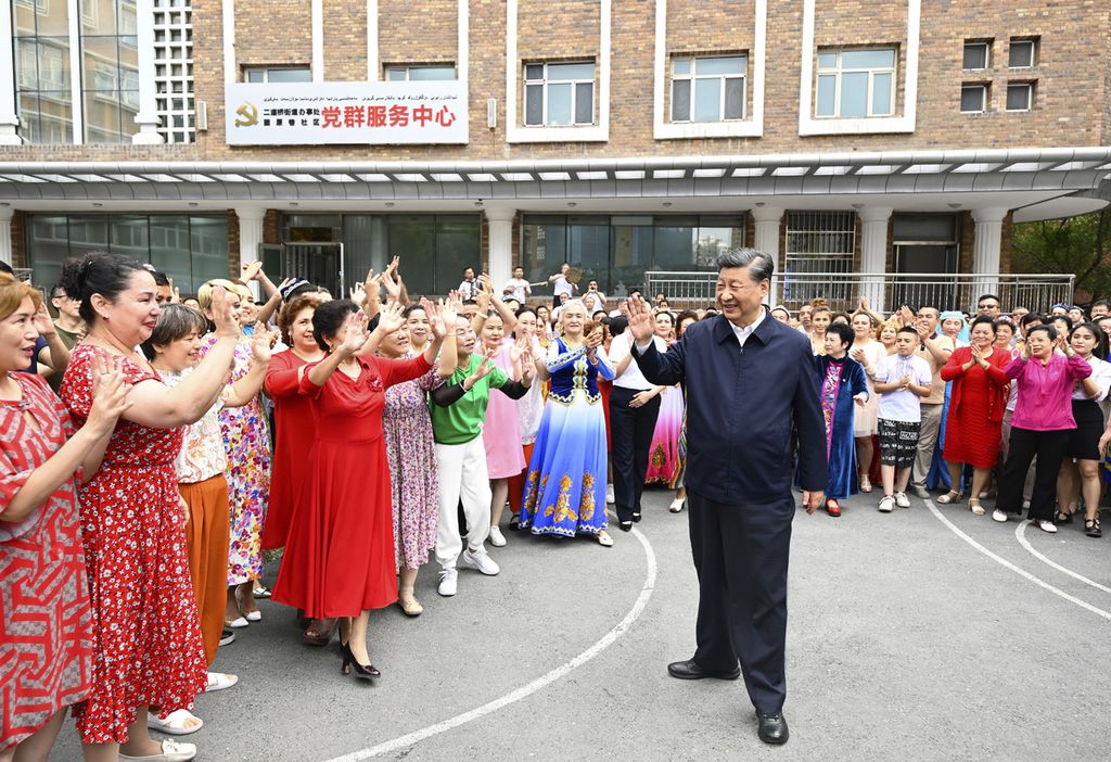 Foto yang dirilis oleh kantor berita Xinhua, 13 Juli 2021, memperlihatkan Presiden China Xi Jinping berada di tengah-tengah warga Guyuanxiang di Distrik Tianshan, Urumqi, Xinjian, China bagian barat.