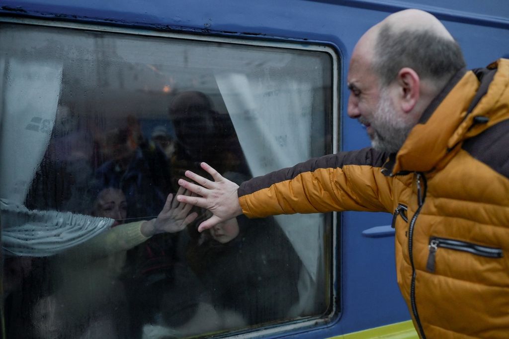 Seorang ayah menangis saat dia mengucapkan selamat tinggal kepada keluarganya di depan kereta evakuasi di stasiun kereta pusat di Odessa, Ukraina, Senin (7/3/2022). Gelombang pengungsi Ukraina terus mengalir keluar negara yang tengah diinvansi Rusia itu. Para laki-laki bertahan untuk beruang mempertahankan negara mereka.
