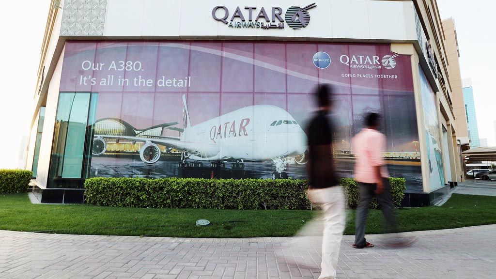 Dua orang sedang berjalan melewati kantor Qatar Airways di Manama, Bahrain, 8 Juni 2017. 