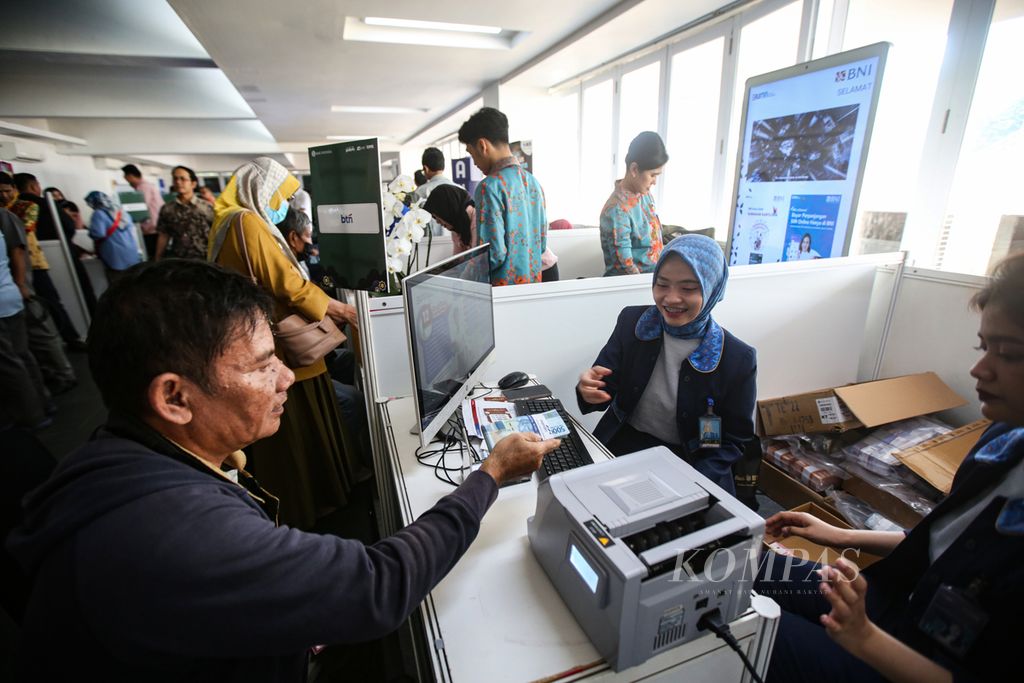 Petugas dari Bank BTN melayani penukaran uang di layanan kas keliling terpadu yang diselenggarakan oleh Bank Indonesia bersama perbankan di Istora Senayan, Jakarta, Kamis (28/3/2024). 