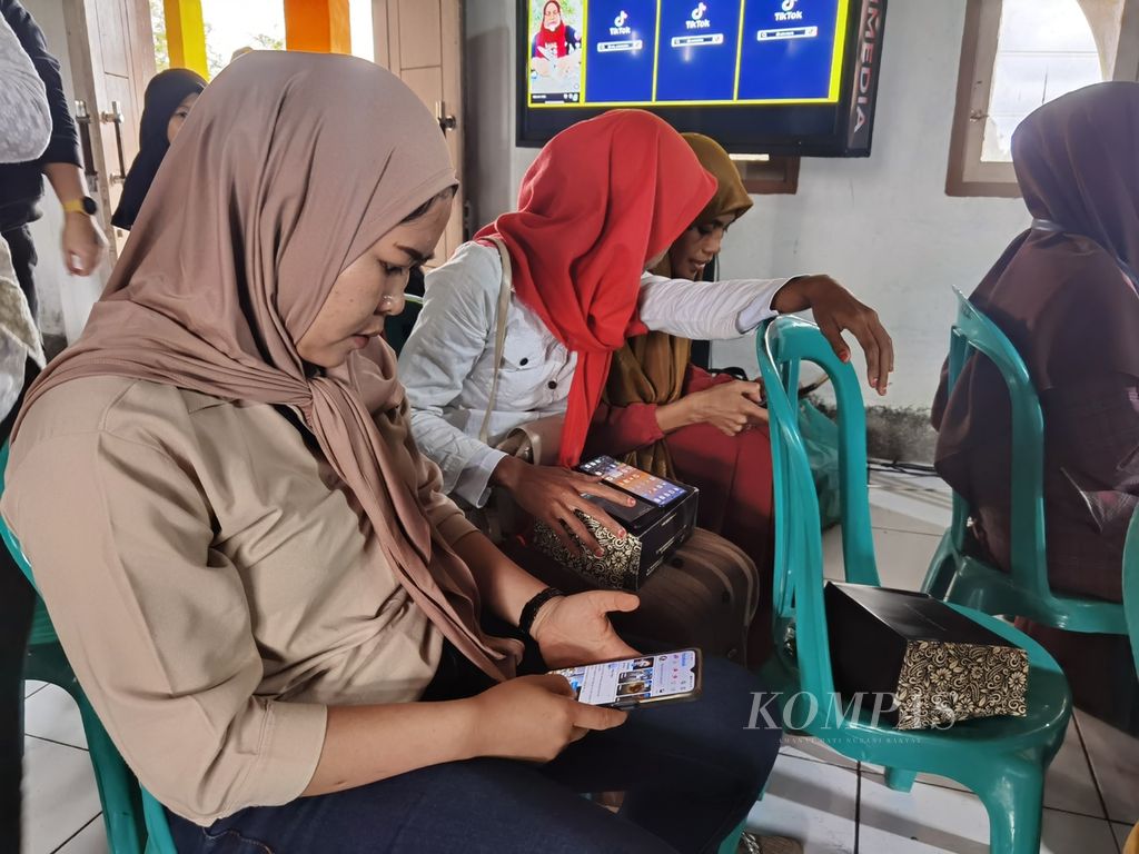 Warga membuka ponsel pintarnya saat praktik dalam pelatihan pemasaran produk melalui media sosial di Desa Pagutan, Kecamatan Batukliang, Lombok Tengah, Nusa Tenggara Barat, Jumat (7/7/2023). 