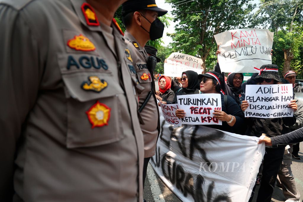 Polisi menjaga ketat aksi unjuk rasa yang dilakukan di depan kantor KPU Jawa Tengah di Kota Semarang, Rabu (21/2/2024). 