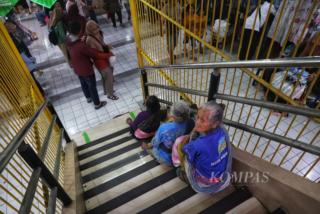 A number of workers carrying elderly people wait for users of their services at Beringharjo Market, Yogyakarta, Monday (1/1/2024).