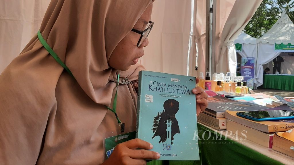Ketua Umum Komunitas Perempuan Menulis Khatulistiwa (Kopermekha Bekate) menunjukkan salah satu buku karya mereka di stan acara Hari Buku Nasional di Taman Alun Kapuas, Kota Pontianak, Kalimantan Barat, Rabu (17/5/2023).