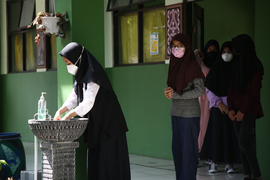 Siswa mengantre untuk mencuci tangan saat jam istirahat pada hari pertama pelaksanaan sekolah tatap muka di SMP Negeri 2 Kota Bekasi, Jawa Barat, Senin (22/3/2021).  