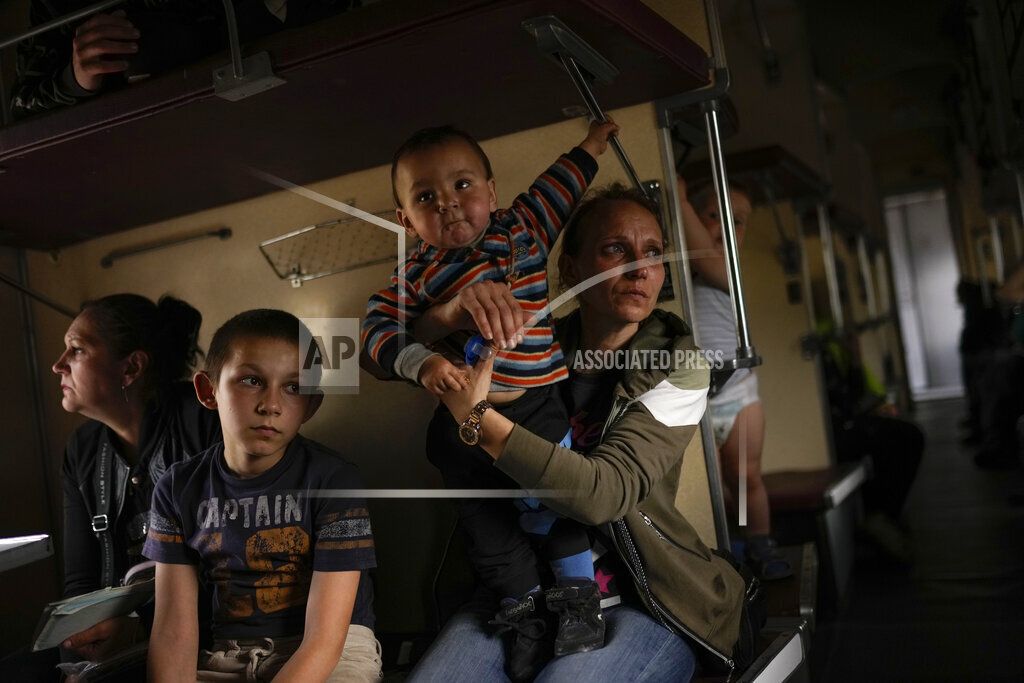 Yana Skakova and her son Yehor who fled from Lysychansk with other people sit in an evacuation train at the train station in Pokrovsk, eastern Ukraine, eastern Ukraine, Saturday, May 28, 2022. Fighting has raged around Lysychansk and neighbouring Sievierodonetsk, the last major cities under Ukrainian control in Luhansk region. 