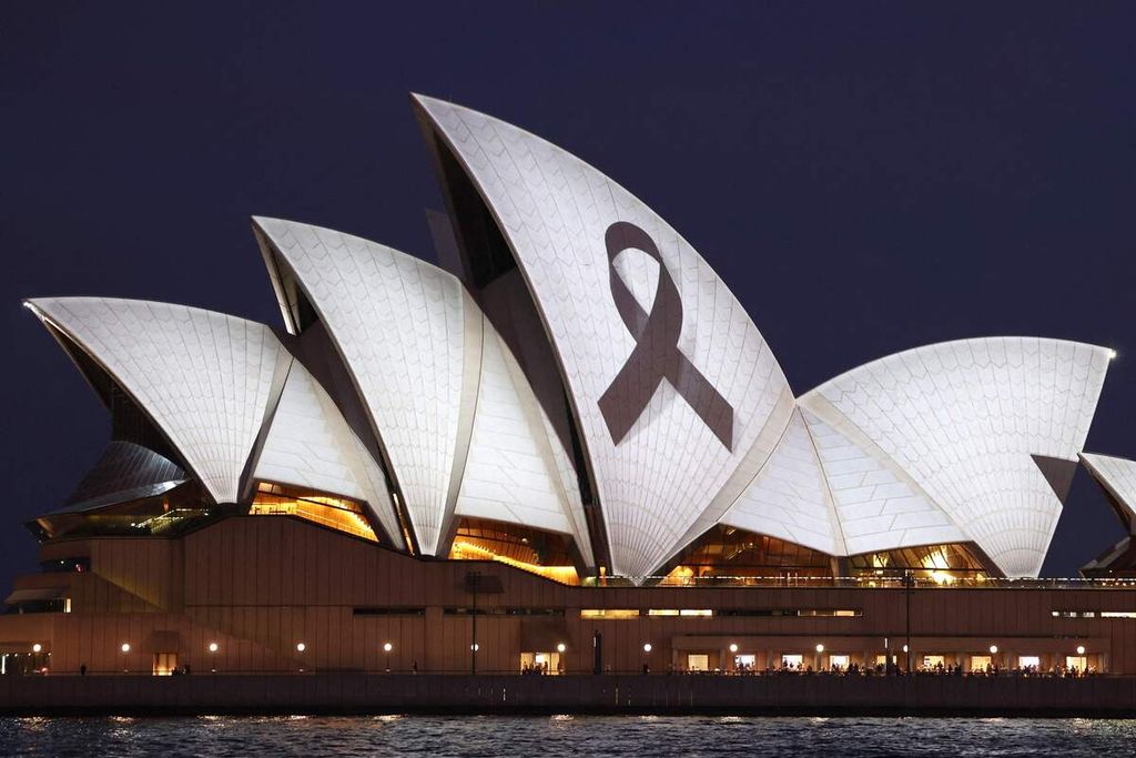 Pita hitam tanda berkabung disorotkan ke gedung Opera Sydney, Senin (15/4/2024). 