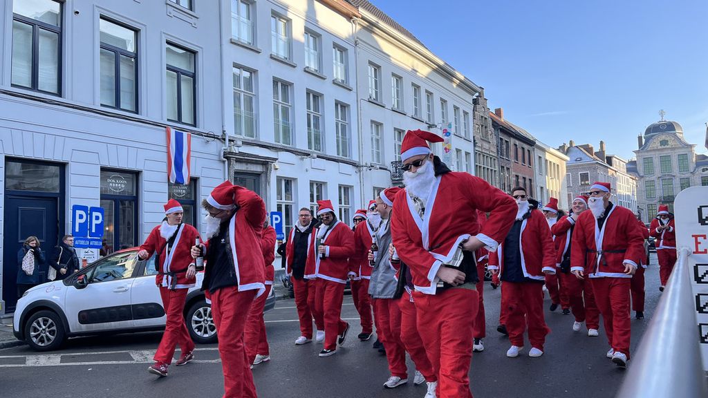 Gerombolan pemuda yang berkeliling mengenakan kostum Sinterklas di Vrijdagmarkt, Ghent, Belgia, Sabtu (17/12/2022). Mereka berkeliling dari siang hingga malam waktu setempat yang menyemarakkan suasana Natal.