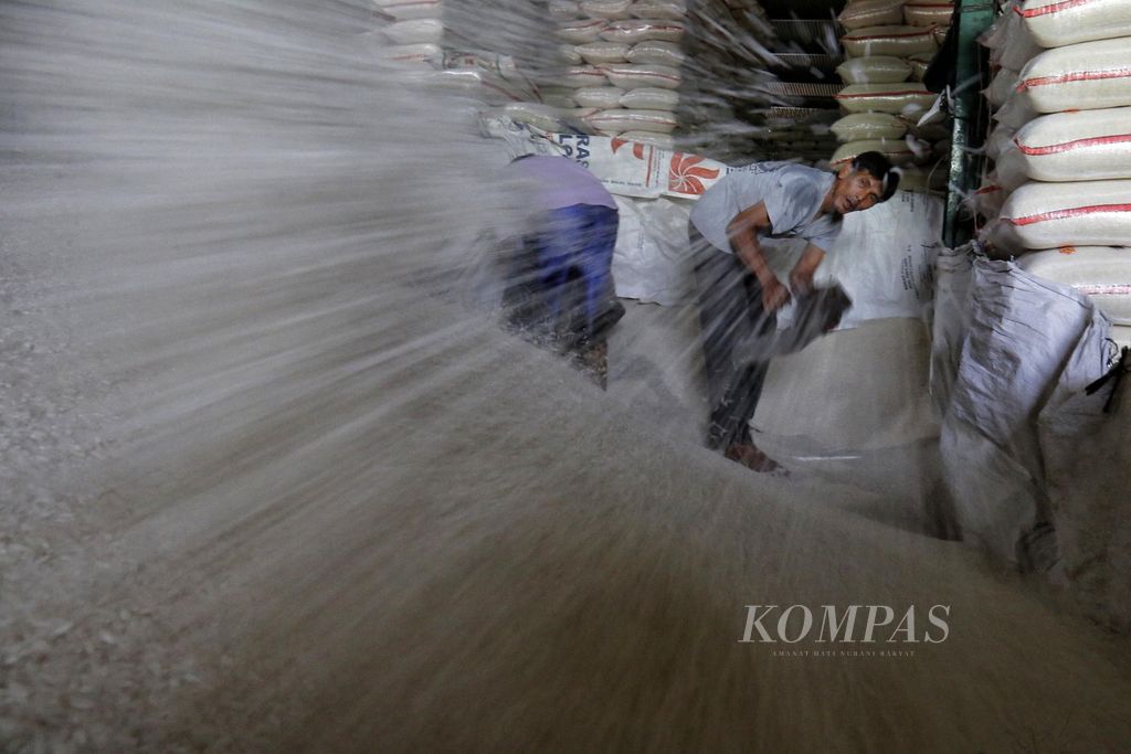 Buruh mengaduk beras di Pasar Induk Beras Cipinang, Jakarta Timur, Selasa (11/7/2023).