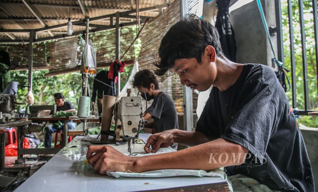 Puluhan penjahit menyelesaikan pembuatan baju di sebuah usaha kenveksi milik Enca di Curug, Bogor, Jawa Barat, Sabtu (27/2/2021). Pandemi menjadi berkah bagi Enca dengan membeludaknya pesanan jahit baju, masker, dan alat pelindung diri dari para penjual baju daring.