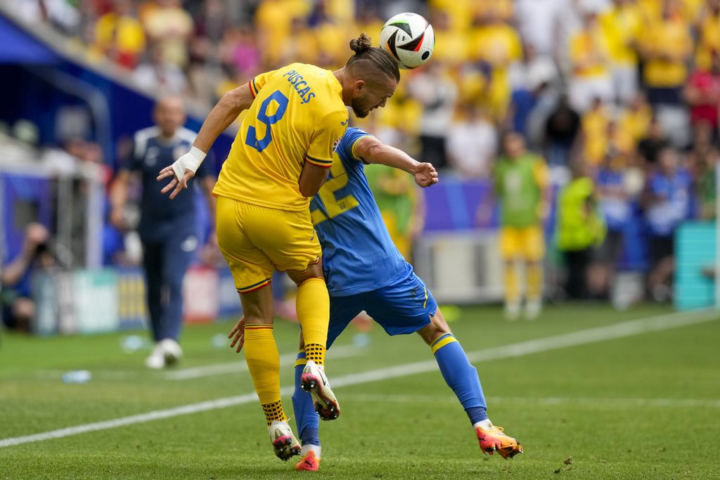 Penyerang Romania, George Puscas, berduel di udara dengan bek Ukraina, Mykola Matviyenko, dalam pertandingan Grup E Piala Eropa 2024 antara Romania dan Ukraina di Stadion Allianz Arena, Muenchen, Senin (17/6/2024). Romania menaklukkan Ukraina, 3-0. 